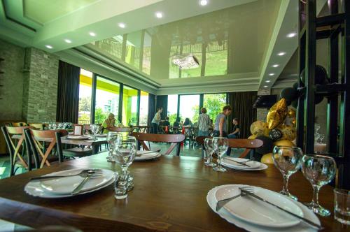 une salle à manger avec une table, des assiettes et des verres dans l'établissement Delta Hotel, à Ureki