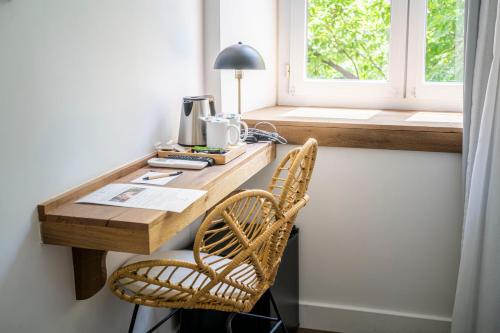 a desk with two chairs in a room with a window at Monsieur Miot Concept Hotel - Bastia centre in Bastia