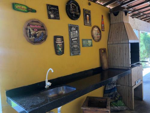 a kitchen with a sink and a wall with clocks at Morro Beach Itarema in Itarema