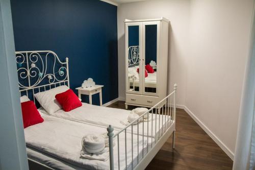 een slaapkamer met een witte wieg en een spiegel bij Apartament Staromiejski Zakątek in Toruń