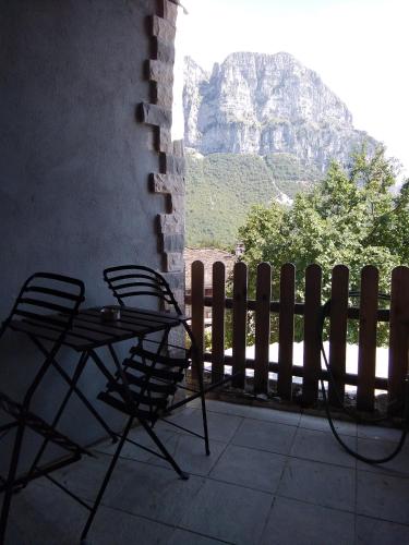a table and chairs on a balcony with a mountain at Radovoli in Papigko