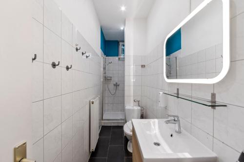 Un baño blanco con lavabo y espejo. en primeflats - Apartments Genter Berlin-Wedding, en Berlín