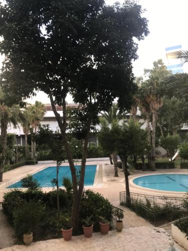 uma vista para uma piscina com árvores e plantas em Complexe Jardins andalouse em Tânger