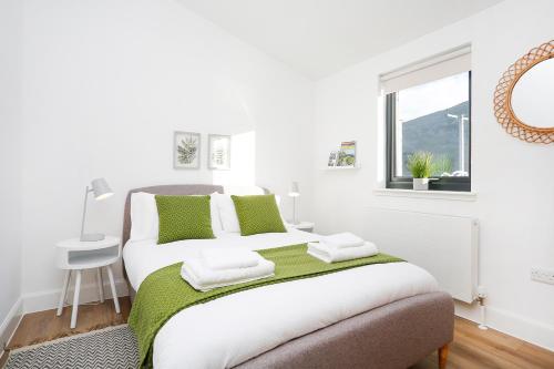 a white bedroom with a bed and a window at Castlehill cabin with a hot tub in Peebles
