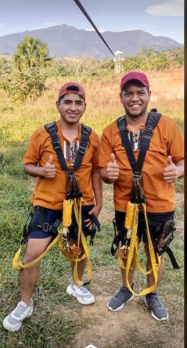 two men are giving thumbs up while holding their equipment at Victtorios Hotel in Satipo
