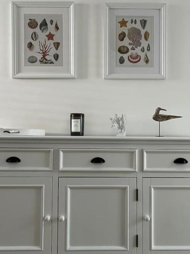 a white counter with two pictures on the wall at Casa Matilde a pochi passi dal mare in Torre Squillace