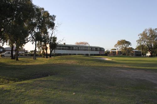 a golf course with a building in the background at Emerald Executive Apartments in Emerald