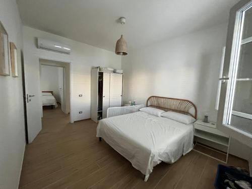 a bedroom with a white bed in a room at Casa Matilde a pochi passi dal mare in Torre Squillace