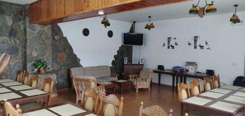 a dining room with tables and chairs and a tv at Pensiunea La Turcu in Moieciu de Sus