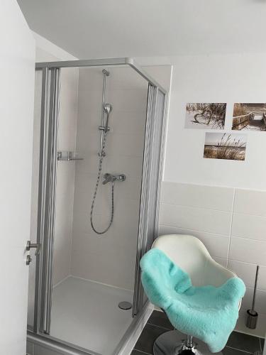 a bathroom with a shower with a chair in it at Strandgut in Ostseebad Sellin