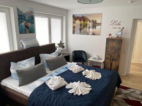 une chambre avec un lit bleu avec des serviettes dessus dans l'établissement Strandgut, à Sellin
