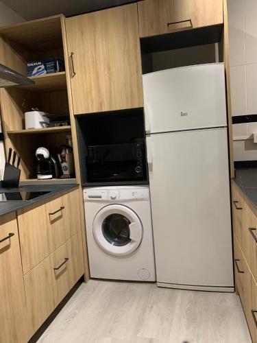 a kitchen with a white refrigerator and a washing machine at Salabardoa Ea in Ea