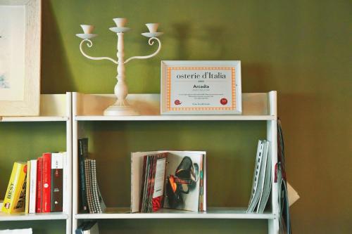a book shelf with books and a box on it at Borgo di Arcadia in Porto Tolle