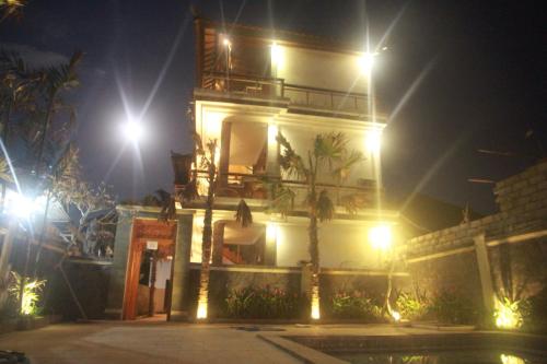 a building with lights in front of it at night at D'Camel Hotel Lembongan in Nusa Lembongan