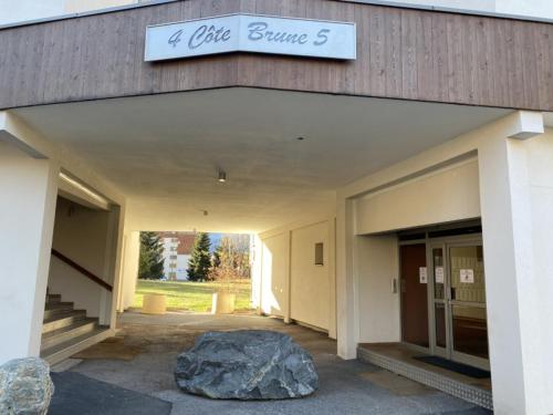 un bâtiment avec un grand rocher devant lui dans l'établissement Cote Brune 5, à Les Deux Alpes