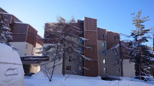 un edificio con nieve en el suelo delante de él en Cote Brune 5, en Les Deux Alpes