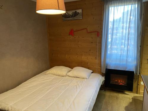 レ・デュー・アルプにあるCote Brune 5のベッドルーム1室(ベッド1台、暖炉付)