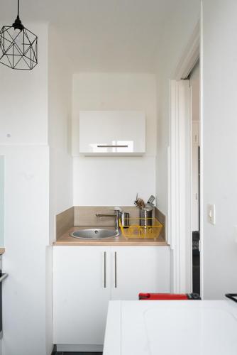 une cuisine avec des armoires blanches et un évier dans l'établissement Studio cocooning 2 étoiles I wifi I clim I plage 7min à pied, à Fréjus