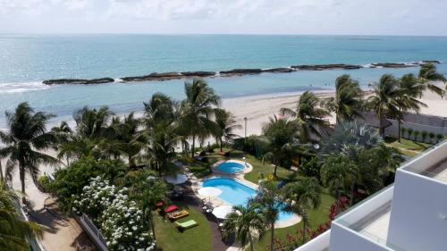 uma vista para a praia a partir da varanda de um resort em As Coloridas em Praia dos Carneiros