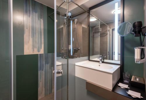 łazienka z umywalką i lustrem w obiekcie Hunguest Hotel Bál Resort w mieście Balatonalmádi