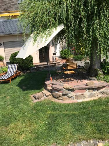 a patio with a table and bench under a tree at 3 Zimmer Loft mit Sauna & Garten in Ortenberg in Ortenberg