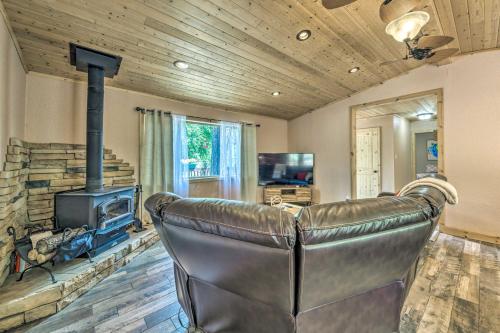 a leather couch in a living room with a fireplace at Sleepy Bear Cabin in Ruidoso Deck and Yard Games! in Ruidoso
