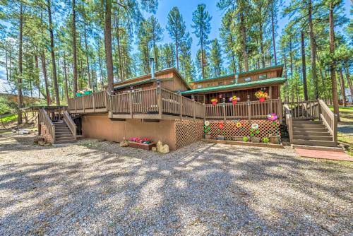 a large house with stairs and flowers in a yard at Sleepy Bear Cabin in Ruidoso Deck and Yard Games! in Ruidoso