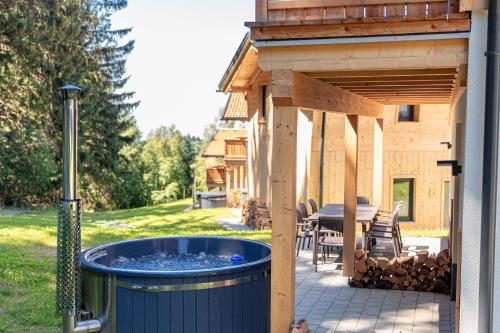 a hot tub in the backyard of a house at Englmar Chalets by ALPS RESORTS in Sankt Englmar