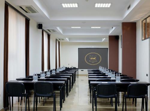 a row of tables in a room with a screen at Ani Central Inn in Yerevan