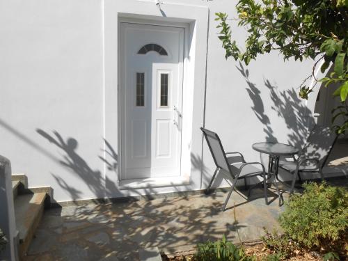 a white door with a table and chairs on a patio at Chrysolithos Kerami Apartments in Khalkíon