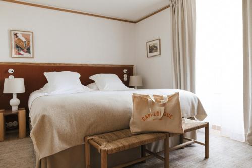 Un dormitorio con una cama grande con una bolsa. en Capelongue, a Beaumier hotel & Spa en Bonnieux