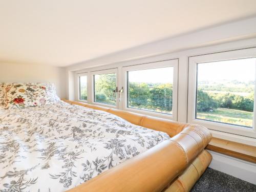 ein Schlafzimmer mit einem Bett und zwei Fenstern in der Unterkunft Cuckoo Nest in Chesterfield