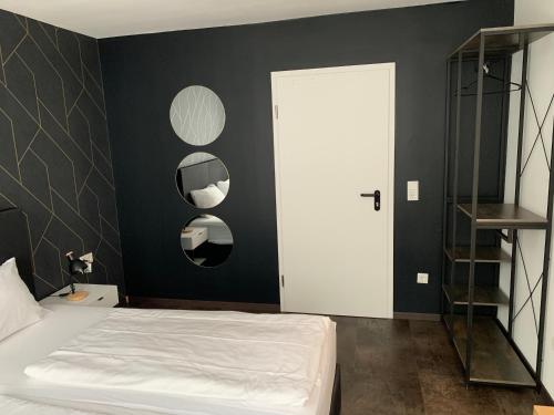 a bedroom with a white bed and a black wall at MOTELO Bielefeld - Smart HOTEL in Bielefeld