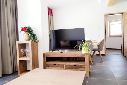 salon z telewizorem i stołem w obiekcie Apartment Goaßa - Familie Zehner w mieście Göriach