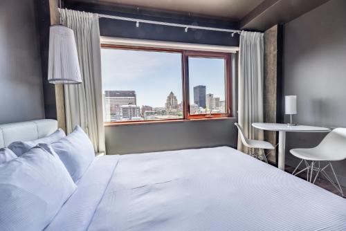 a bedroom with a large bed and a window at Hotel Zero 1 Montreal in Montréal