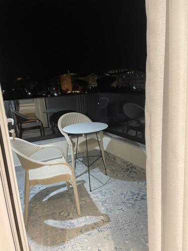 a table and chairs on a balcony at night at Adria Hotel in Golem