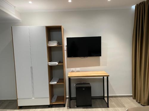 a room with a desk and a tv on a wall at Adria Hotel in Golem