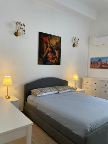 Un dormitorio con una cama y un cuadro en la pared. en Casa in piazzetta, en Balestrate