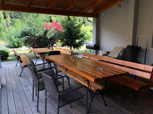 a patio with wooden tables and chairs and a television at Penzion Sidorovo in Ružomberok