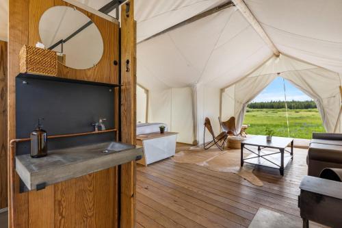 a room with a tent with a couch and a table at Under Canvas West Yellowstone in West Yellowstone