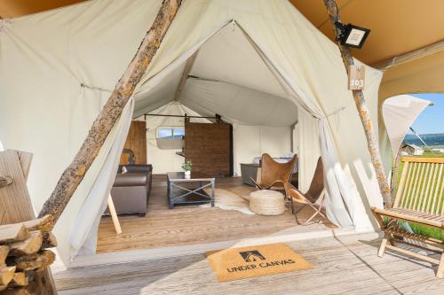 a canvas tent with a couch and a table at Under Canvas West Yellowstone in West Yellowstone