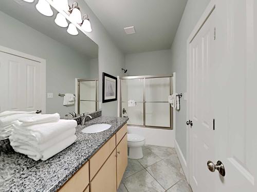 a white bathroom with a sink and a toilet at Beach Music in Gulf Shores