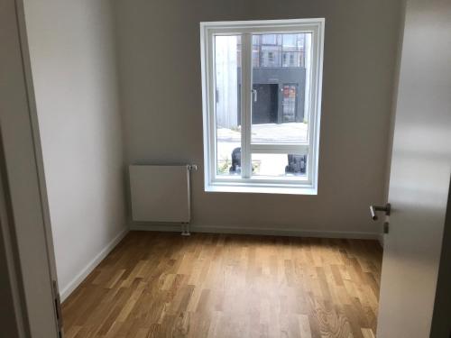 an empty room with a window and a wooden floor at Single Room in SHARED APARTMENT with single bed in Copenhagen