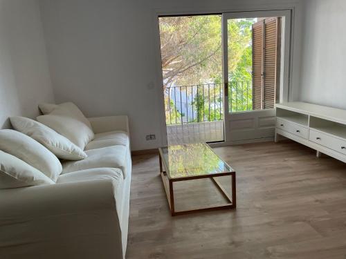 a living room with a couch and a glass table at Modern apartment with parking 2 min from the beach in Calella de Palafrugell