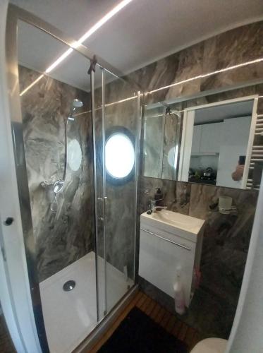 a bathroom with a shower and a toilet and a sink at Domek pływający HouseBoat 4U in Ruciane-Nida