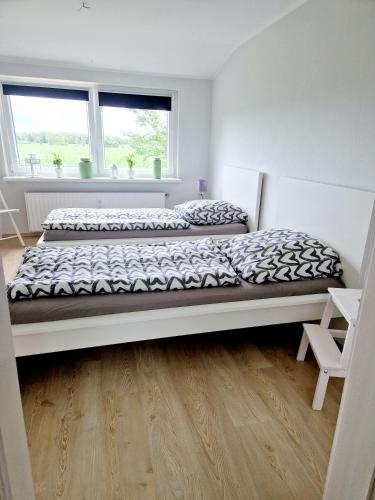 a bedroom with two beds and a wooden floor at Friesenparadies FRI-Südliches Friesland in Bockhorn