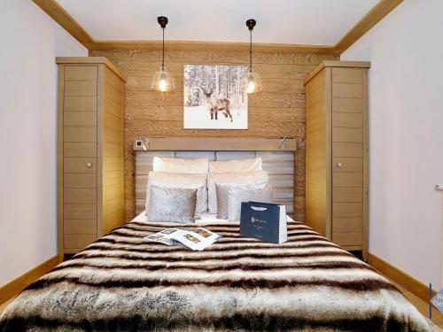 Un dormitorio con una cama grande con un libro. en Appartement Courchevel 1550, 5 pièces, 8 personnes - FR-1-664-4, en Courchevel