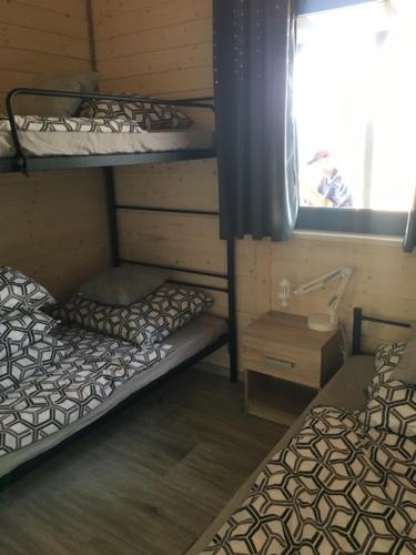 two bunk beds in a room with a window at Domki Tręby Stare in Tręby