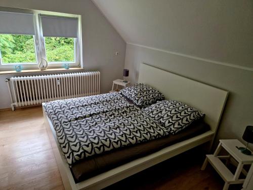a bedroom with a bed and two windows at Friesenparadies FRI-Südliches Friesland in Bockhorn