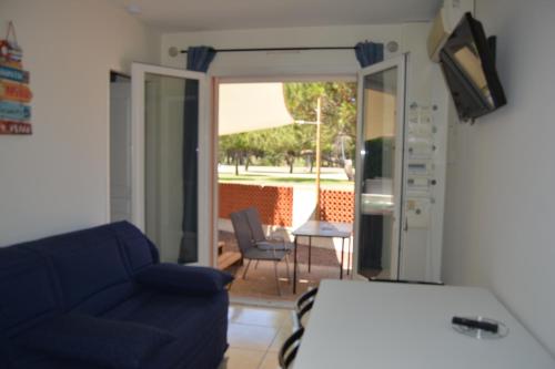 - un salon avec un canapé bleu et une porte coulissante en verre dans l'établissement rêve méditerranéen, Maison de rêve, au Barcarès